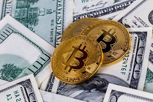 three bitcoin shiners on paper us dollar banknotes background.