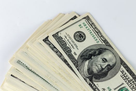 a skewed stack of old us dollar banknotes on white background - close shot.