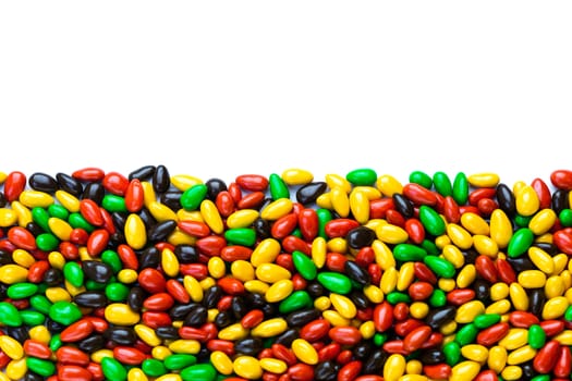 hundreds of small gloss glazed sunflower seeds multicolor flat background with selective focus with isolated side on white backgroud