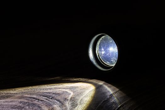 Black led operational flashlight on rough wooden surface - closeup with selective focus. Nighttime covert activity or search background.