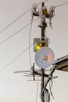 Frozen 5 GHz wireless antenna repeater pillar at winter night.