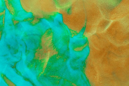 Mixed brown-green flat plastilin texture with distinct finger prints. Small dust particles on bumpy surface.