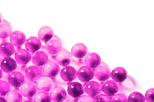 plastic pink spherical ball capsules with selective focus isolated on white background.