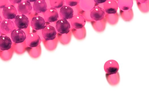 plastic pink spherical ball capsules with selective focus isolated on white background.