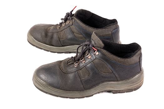 a pair of used blue leather work shoes with fabric incuts isolated on white background.