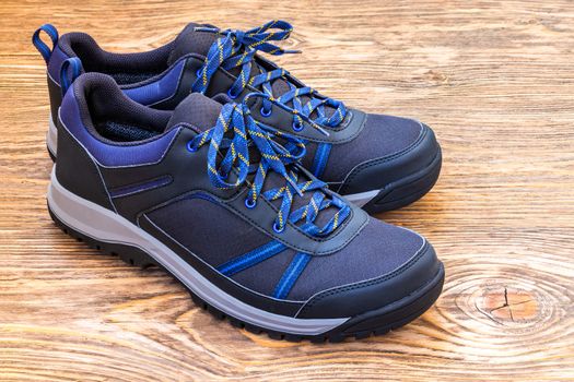 black and blue outdoor empty clean lightweight waterproof sneakers on wooden surface
