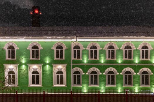 green house under winter dark night snowfall.