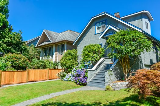 Residential house with the pathway over front yard lawn on blue sky background