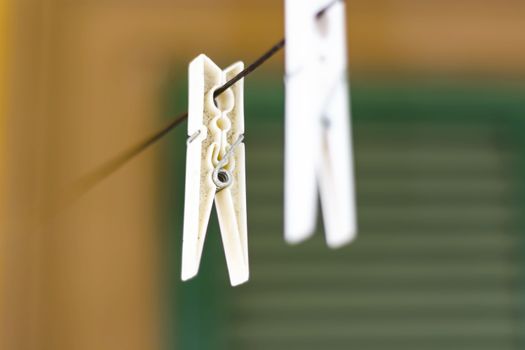 a white plastic clothespin hanging. housework and laundry