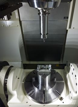 The five-axis Computer Numerical Control CNC machine waiting for stock change.