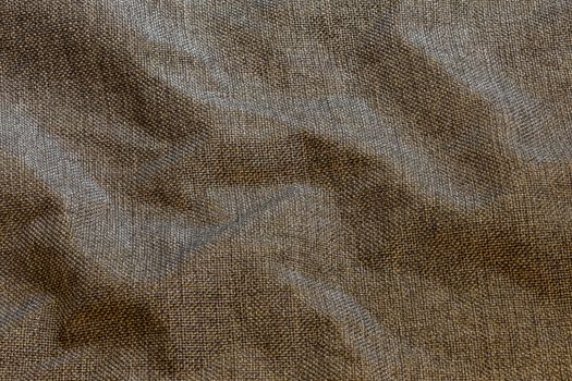 Brown crumpled dense rough fabric background, close up withoun any blurring