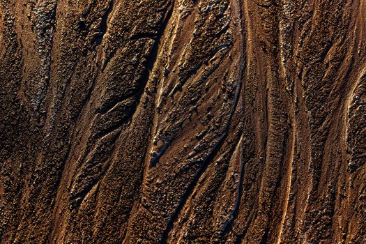 abstract mud background with water washout trails and selective focus.