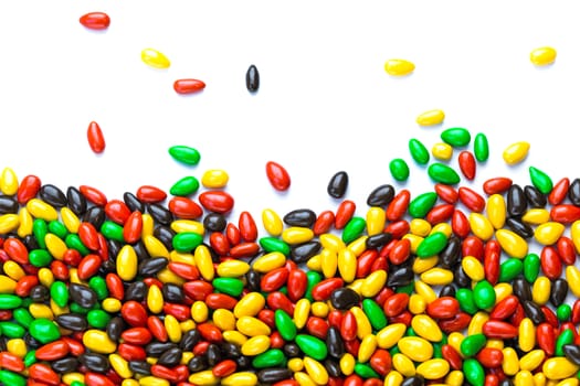 hundreds of small gloss glazed sunflower seeds multicolor flat background with selective focus with isolated side on white backgroud