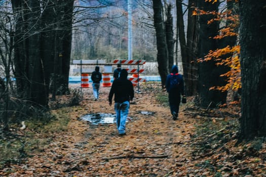 A Group of Young Men Exiting the Autumn Woods Onto a Road