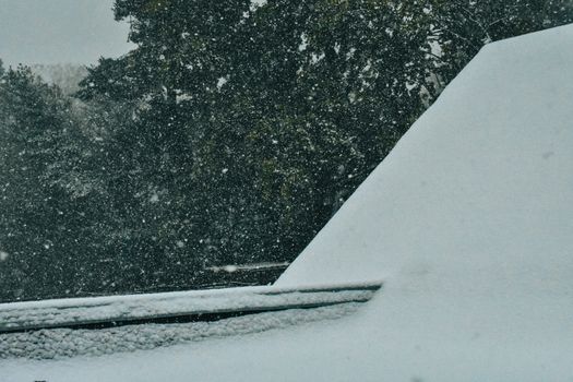 Looking Over a Snow Covered Roof Top During a Harsh Snow Storm