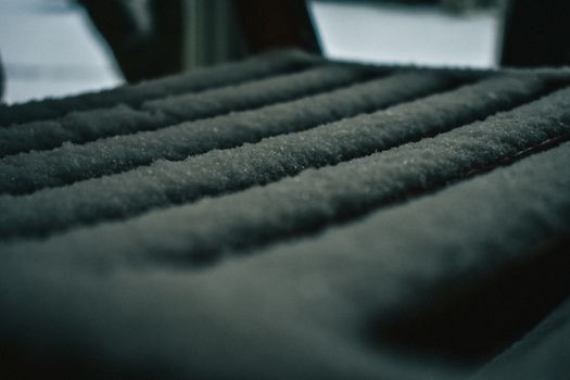 A Close-Up Shot of a Wooden Seat Covered in a Fresh Layer of Snow