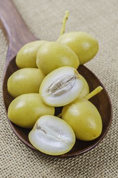 A bunch of fresh date palm fruits on sack background.