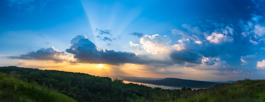 Panorama Sunset with ray light on clouds in a blue and orange sky in twilight time