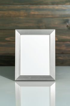 Picture siver frame mock up over table with wood wall background