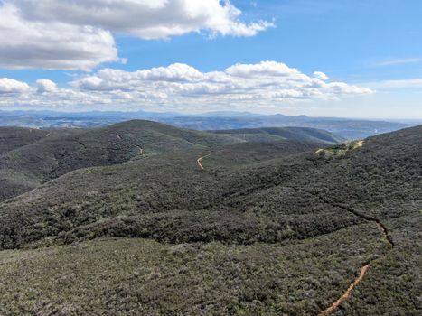 Aerial view of Black Mountain in Carmel Valley, San Diego, California, USA. Green dry mountain during sunny cloudy day with hiking trails, perfect for sport activity an leisure time..