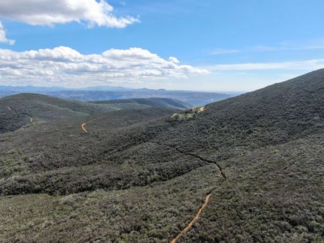 Aerial view of Black Mountain in Carmel Valley, San Diego, California, USA. Green dry mountain during sunny cloudy day with hiking trails, perfect for sport activity an leisure time..