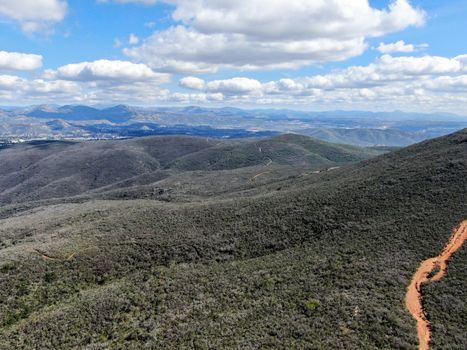 Aerial view of Black Mountain in Carmel Valley, San Diego, California, USA. Green dry mountain during sunny cloudy day with hiking trails, perfect for sport activity an leisure time..