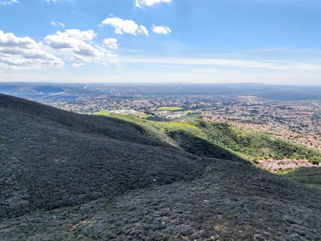 Aerial view of Black Mountain in Carmel Valley, San Diego, California, USA. Green dry mountain during sunny cloudy day with hiking trails, perfect for sport activity an leisure time..