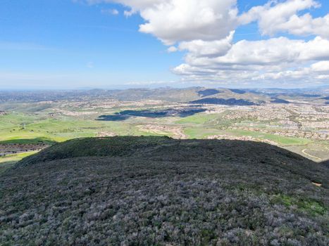 Aerial view of Black Mountain in Carmel Valley, San Diego, California, USA. Green dry mountain during sunny cloudy day with hiking trails, perfect for sport activity an leisure time..