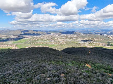 Aerial view of Black Mountain in Carmel Valley, San Diego, California, USA. Green dry mountain during sunny cloudy day with hiking trails, perfect for sport activity an leisure time..