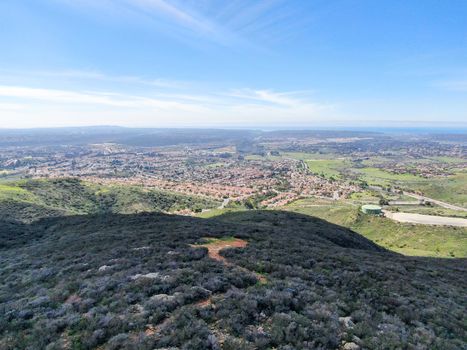 Aerial view of Black Mountain in Carmel Valley, San Diego, California, USA. Green dry mountain during sunny cloudy day with hiking trails, perfect for sport activity an leisure time..