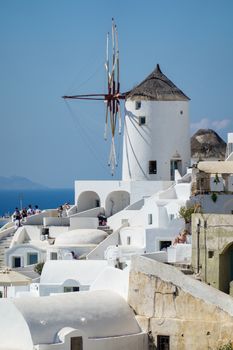 Architecture with windmills on a hillside in Oia village on Santorini island, Greece Mediterranean sea.