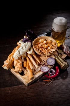 Cheese and glass of beer on a wooden background