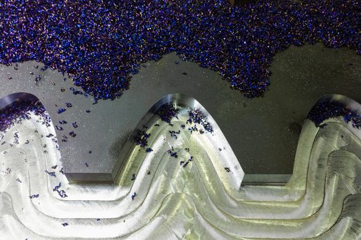 flat semifinished cnc milled plate with curves and layer of small blue discoloration chips