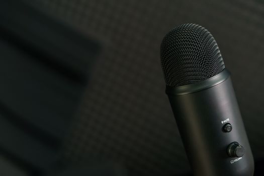 Close-up of professional condenser microphone on a black background.