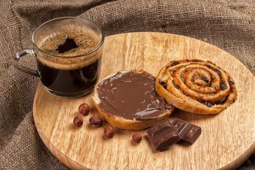 Cup and and pastry with chocolate on a wooden desk