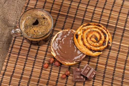 Cup and and pastry with chocolate on a wooden desk