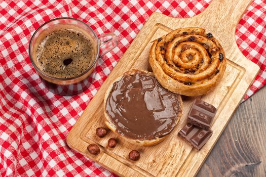 Cup and and pastry with chocolate on a wooden desk