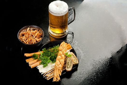 Cheese and glass of beer on a glass background