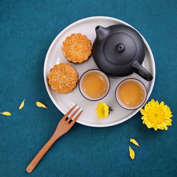 Minimal simplicity layout moon cakes on blue background for Mid-Autumn Festival, creative food design concept, top view, flat lay, copy space.