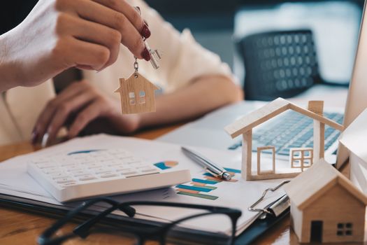 Real estate agent with house model and keys for financial or loan.