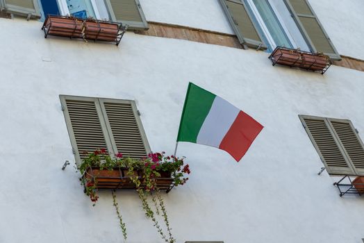 Italian flag placed on a balcony in the town of Spoleto