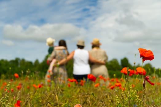 Family Standing In Poppy Field on sunny day, blured, selective focus