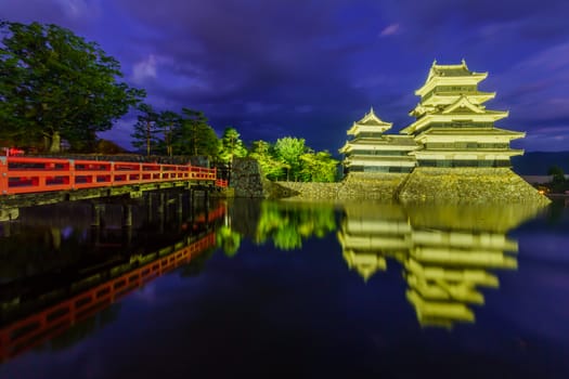 Night view of the Matsumoto Castle (or Crow Castle) and bridge, in Matsumoto, Japan