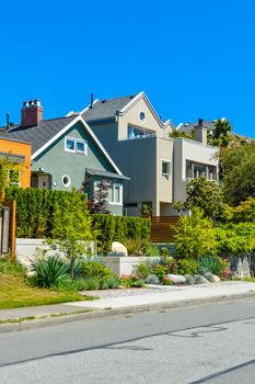 Modern residential houses on the street with landscaped front yards on terraces