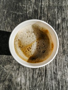 Paper cup with coffee to go on wooden ground texture from above. Leherheide, Bremerhaven.