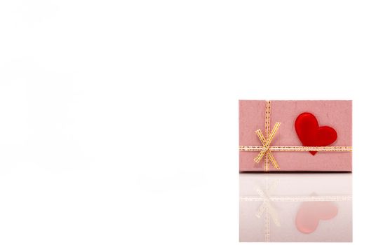Front View of a Pink Gift Box With a Red Heart Attached to it. Concept of St. Valentine’s Day. Isolated on White Background.