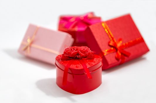 Front View of a Bunch of Colorful Gift Boxes With Ribbons and Bows on White Background. Christmas or Valentine’s Day Theme