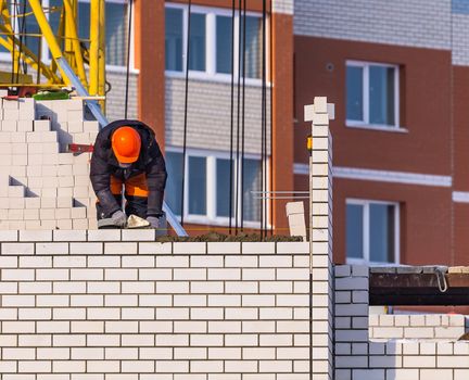 View of Construction Worker Laying Bricks. Construction Site Concept.