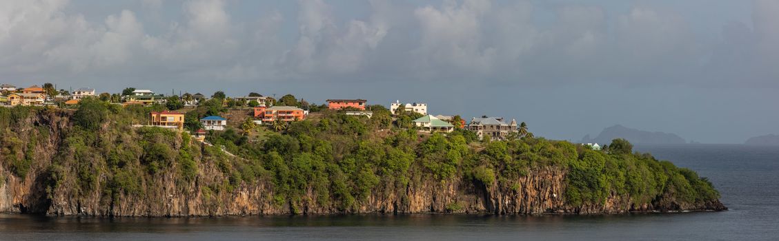 Beautiful panoramic aerial view of a cliff with some buildings and houses on it on St. Vincent island