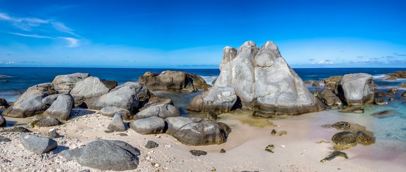 Beautiful panoramic landscape of a rocky beach in Aruba. Amazing blue sky as a background